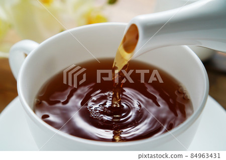 Black tea poured into a tea cup 84963431