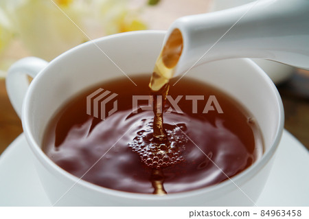Black tea poured into a tea cup 84963458