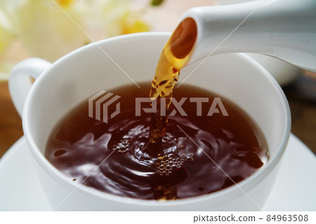 Black tea poured into a tea cup 84963508