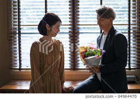 Senior couple present bouquet Senior couple present bouquet 84964470