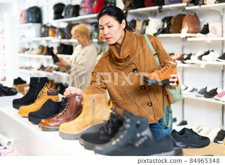 woman selecting new footwear in shoe store woman selecting new footwear in shoe store 84965348