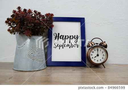 Happy September typography text with alarm clock and artificial plant decoration on wooden table and white wall background Happy September typography text with alarm clock and artificial plant decoration on wooden table and white wall background 84966599