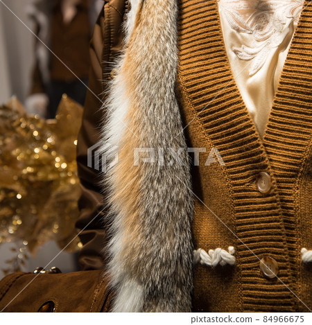 The main element of clothing is the skin of a fox. Natural fur. Clothes in yellow and orange, mustard tones. Trendy color in clothes. Exquisite toilet. Luxury quality of expensive clothes. A 84966675