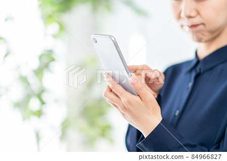 操作智能手機的年輕女子（零件） 84966827