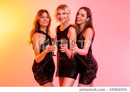 happy beautiful girls holds glasses of champagne celebrates Christmas on color background 84968950