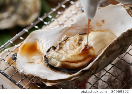 Sprinkle soy sauce on the grilled oysters Sprinkle soy sauce on the grilled oysters 84969502