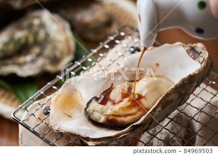 在烤牡蠣上撒上醬油 84969503