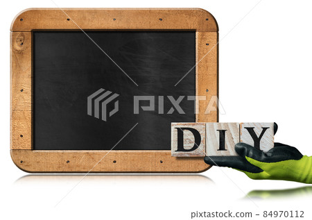 Hand with Work Gloves Holding a Diy Text made of Wooden Blocks 84970112