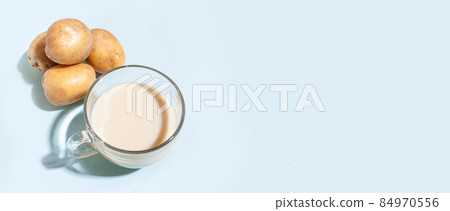 Potato milk. A cup with milk and potato tubers. Alternative plant milk 84970556