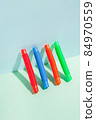 The straight folded pop tube stands leaning against the wall. Modern still life with antistress toy 84970559