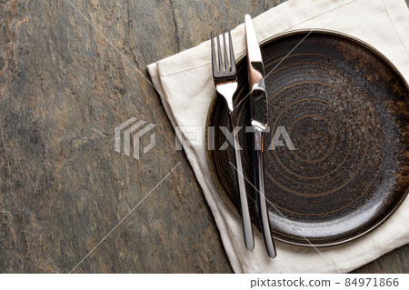 Plate, knife and fork on stone background Plate, knife and fork on stone background 84971866