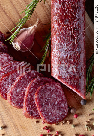 Smoked salami on a old wooden table. 84972126