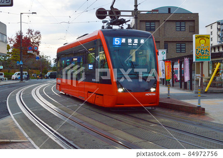 On the afternoon of December 2021, the tram running after the Matsuyama city road is cute On the afternoon of December 2021, the tram running after the Matsuyama city road is cute 84972756