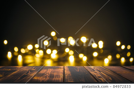Table Christmas background. Lights of golden bokeh and wooden rustic texture surface for food, drinks and presents. 84972833