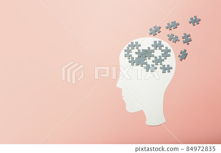 Dementia, alzheimer, memory and mental brain health concept background. Paper head with puzzle pieces on a pink background Dementia, alzheimer, memory and mental brain health concept background. Paper head with puzzle pieces on a pink background 84972835