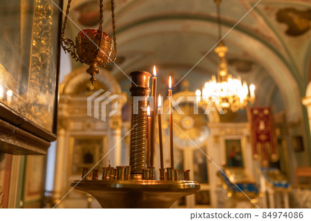 Orthodox Church. Christianity. Festive interior decoration with burning candles and icon in traditional Orthodox Church on Easter Eve or Christmas. Religion faith pray symbol 84974086