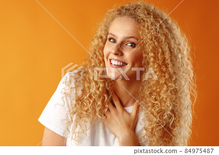 Gorgeous beautiful young woman with curly hair posing at camera 84975487