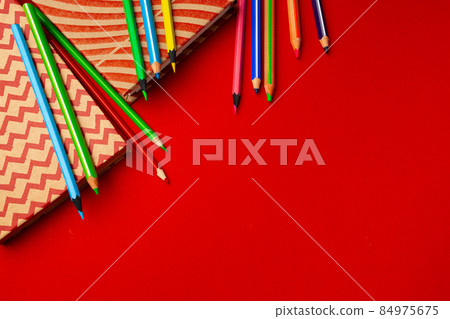 Notepad and color pencils on working space top view Notepad and color pencils on working space top view 84975675