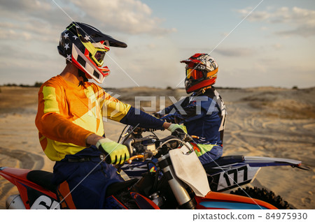 Two motocross MX riders talking before racing Two motocross MX riders talking before racing 84975930