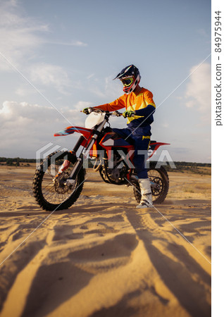 Man on sport motor over sand terrain Man on sport motor over sand terrain 84975944