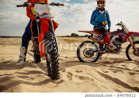 Motocross riders team rest on extreme track Motocross riders team rest on extreme track 84976012