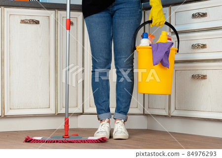 Woman washing floor with mop in kitchen 84976293