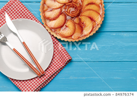 Apple tart pie on blue wooden background Apple tart pie on blue wooden background 84976374