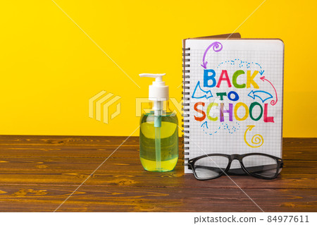 School supplies and hand sanitizer. Pandemic education concept School supplies and hand sanitizer. Pandemic education concept 84977611