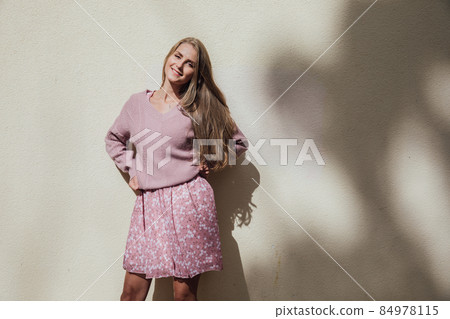 blonde woman in a summer dress on a walk through the streets of the city blonde woman in a summer dress on a walk through the streets of the city 84978115