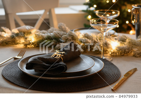 Christmas festive table setting, gold decorate and champagne. Family holiday dinner or New Year party. Christmas festive table setting, gold decorate and champagne. Family holiday dinner or New Year party. 84979933