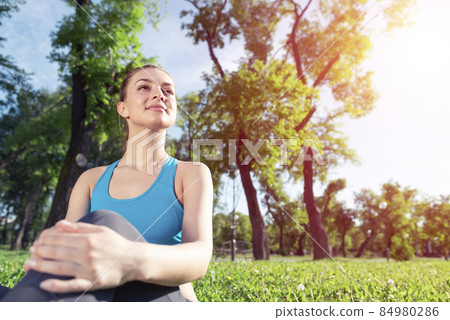 Beautiful smiling girl in sportswear relax in park Beautiful smiling girl in sportswear relax in park 84980286
