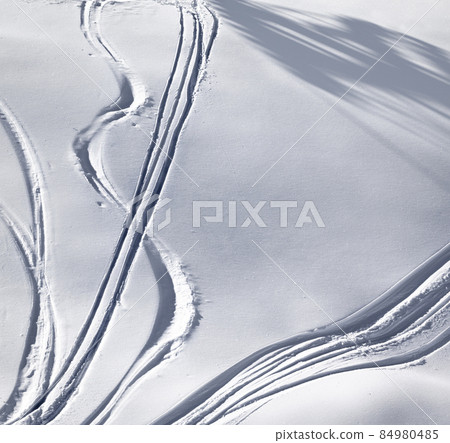 Off-piste slope with track from ski and snowboard on sunny evening 84980485