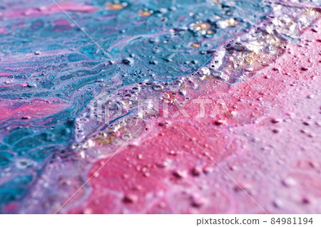Fluid Art. Embossed strokes and drips of pink and turquoise paint. Marble effect background or texture. Selective focus 84981194