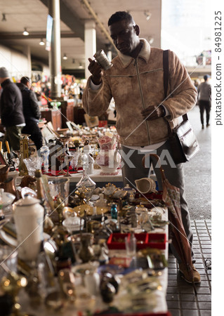 African American man chooses antiques on the flea market 84981225