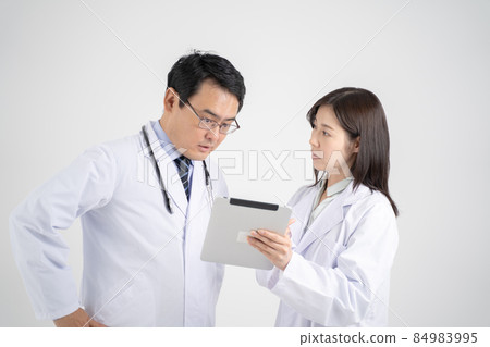 Medical workers in white coats for men and women who consult with tablets ・ White background Medical workers in white coats for men and women who consult with tablets ・ White background 84983995