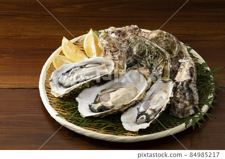 Raw oysters with shells on a colander Raw oysters with shells on a colander 84985217