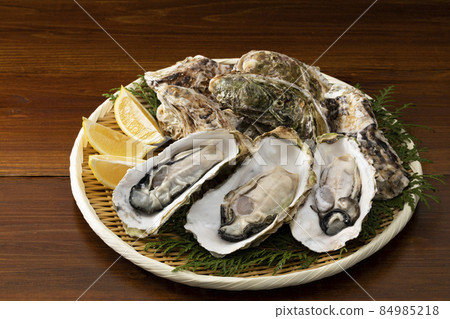 Raw oysters with shells on a colander Raw oysters with shells on a colander 84985218
