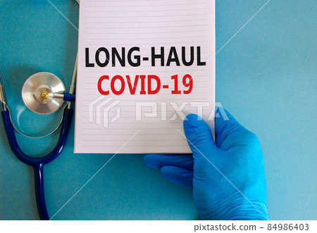 COVID-19 long-haul covid symptoms symbol. White card with words Long-haul covid-19. Doctor hand, stethoscope, blue background, copy space. Medical, COVID-19 long-haul covid-19 symptoms concept. COVID-19 long-haul covid symptoms symbol. White card with words Long-haul covid-19. Doctor hand, stethoscope, blue background, copy space. Medical, COVID-19 long-haul covid-19 symptoms concept. 84986403