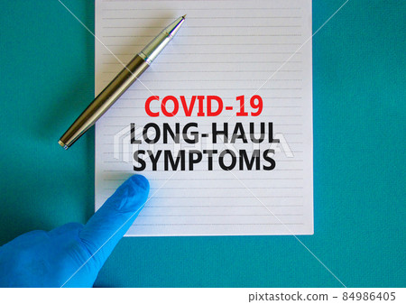 COVID-19 long-haul covid symptoms symbol. White card with words Covid-19 long-haul symptoms. Doctor hand, pen, blue background, copy space. Medical, COVID-19 long-haul covid symptoms concept. COVID-19 long-haul covid symptoms symbol. White card with words Covid-19 long-haul symptoms. Doctor hand, pen, blue background, copy space. Medical, COVID-19 long-haul covid symptoms concept. 84986405