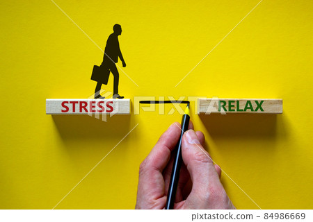 Stress or relax symbol. Wooden blocks with words 'Stress, Relax'. Yellow background. Businessman hand, businessman icon. Psychological, business and stress or relax concept. Copy space. Stress or relax symbol. Wooden blocks with words 'Stress, Relax'. Yellow background. Businessman hand, businessman icon. Psychological, business and stress or relax concept. Copy space. 84986669