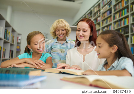 Woman and children reading book together Woman and children reading book together 84987429