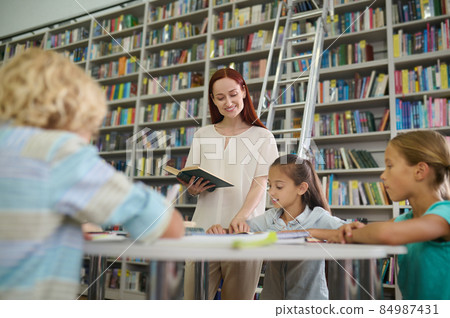 Woman with book looking into girl copybook 84987431