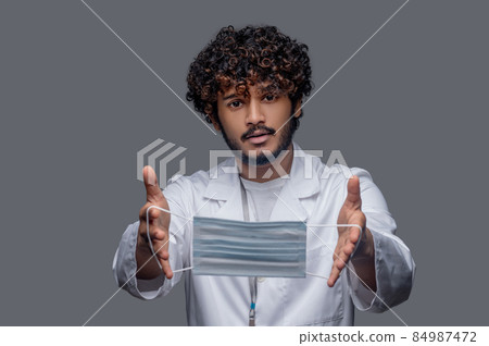 Practitioner demonstrating his face covering before the camera 84987472