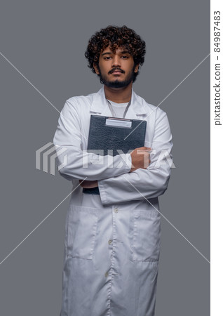 Young doctor with medical documents looking ahead Young doctor with medical documents looking ahead 84987483