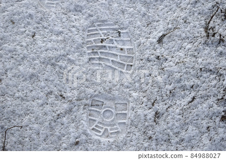 Footprint of shoes on white snow on the road. 84988027