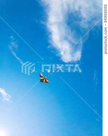 Kite blue sky. Colorful high flying toy. Air kite fly on wind clouds. Rainbow kite in summer background. Concept of dreams, freedom, childhood. 84988088
