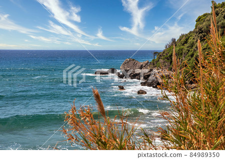 Sea waves crashing onto rocks with water splashes. Corfu island, Greece. Sea waves crashing onto rocks with water splashes. Corfu island, Greece. 84989350