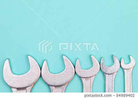 Tools worker, many wrenchs on a blue background, top view with free space Tools worker, many wrenchs on a blue background, top view with free space 84989402