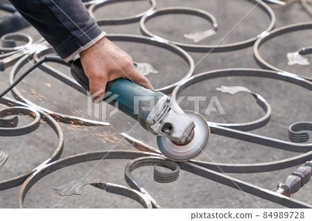 Metal grinding with angle grinder. Male hand and instrument. Working with metal. Metal grinding with angle grinder. Male hand and instrument. Working with metal. 84989728