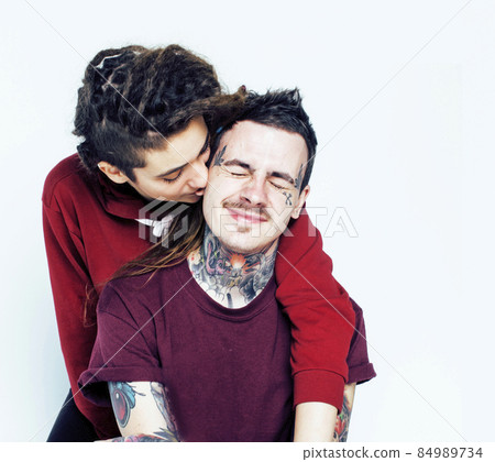 Young couple together. guy with tattoo, girlfriend wearing dreadlocks having fun on white background Young couple together. guy with tattoo, girlfriend wearing dreadlocks having fun on white background 84989734